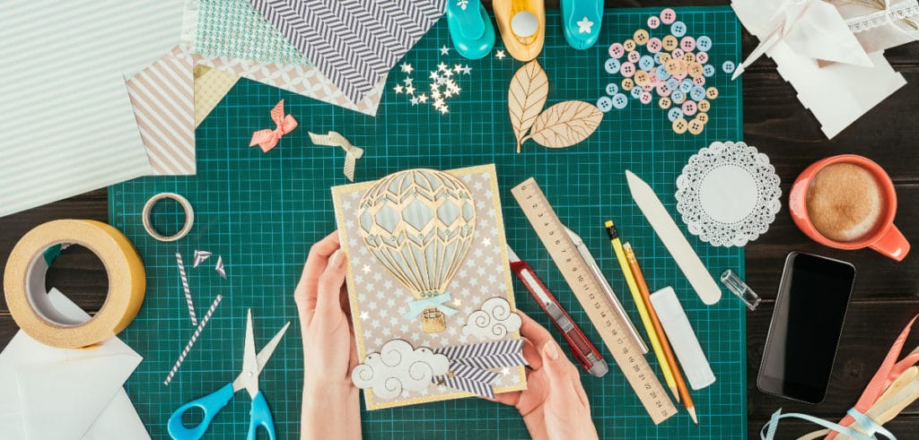 Scrapbooking materials and woman holding a card